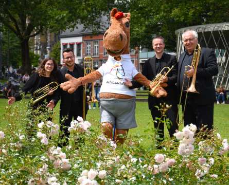 Das Foto zeigt CHIO Aachen-Maskottchen Karli gemeinsam mit vier Musikern des Sinfonieorchesters Aachen (Foto: CHIO Aachen/Caroline Niehus).
